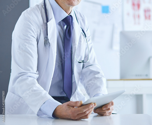 Portrait of a smiling doctor in his bright office