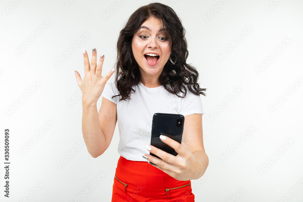 joyful girl with a phone in her hands on a white background with copy space joyful girl with a phone in her hands on a white background with copy space