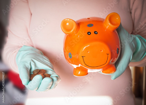 concept image topic coronavirus crisis, piggy bank, hands in gloves and euro coins photo