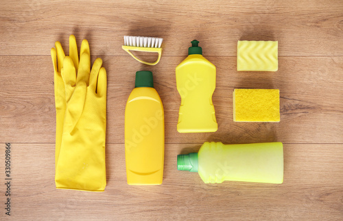 Yellow cleaning products on wood background. Top view