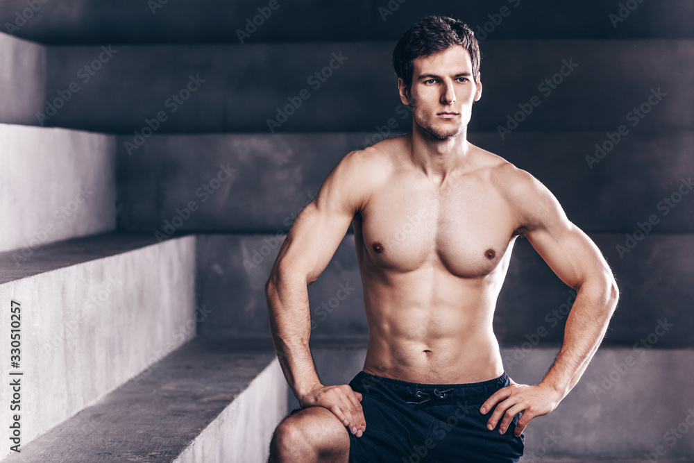 Fitness model man posing in studio.