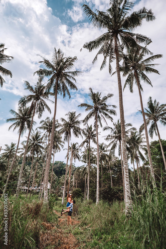 Couple relaxing in palm trees and road in the kohkood ,Thailand