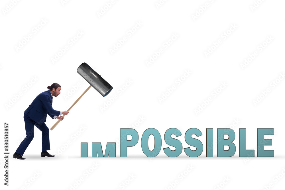 Businessman hitting the word impossible with hammer Businessman hitting the word impossible with hammer