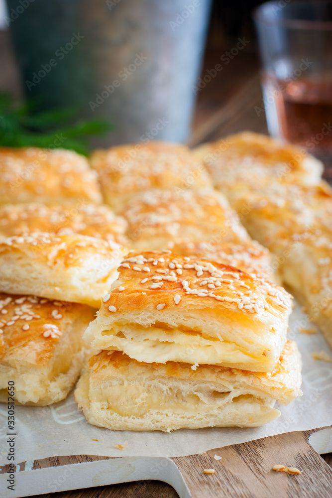 Puff pastry pie with cheese, sprinkled with sesame seeds, selective focus
