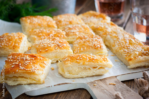 Puff pastry pie with cheese, sprinkled with sesame seeds, selective focus