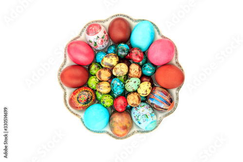 Plate with Easter eggs painted in different colors and different sizes on an isolated white background
