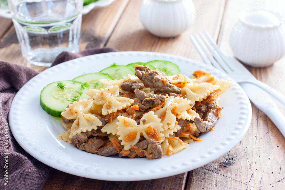 Farfalle with fried chicken liver and carrots, selective focus
