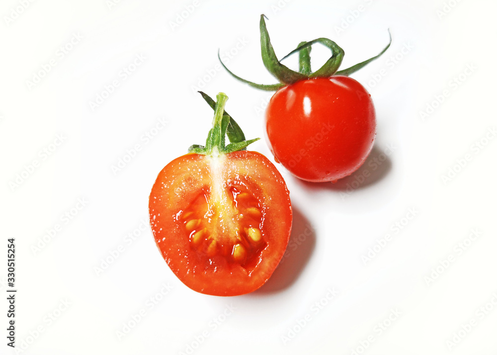 Vegetable series - One small vine cherry tomatoes and one small cut isolated on white background Vegetable series - One small vine cherry tomatoes and one small cut isolated on white background