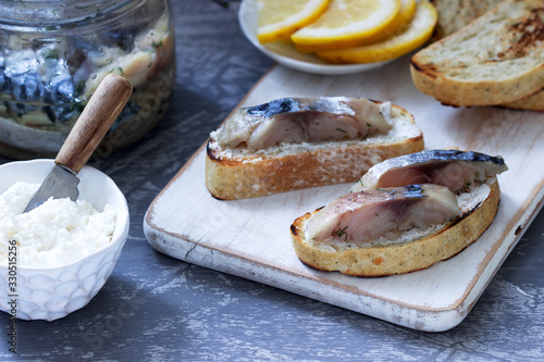 Sandwiches with cottage cheese and gravlax from mackerel, served with lemon. photo