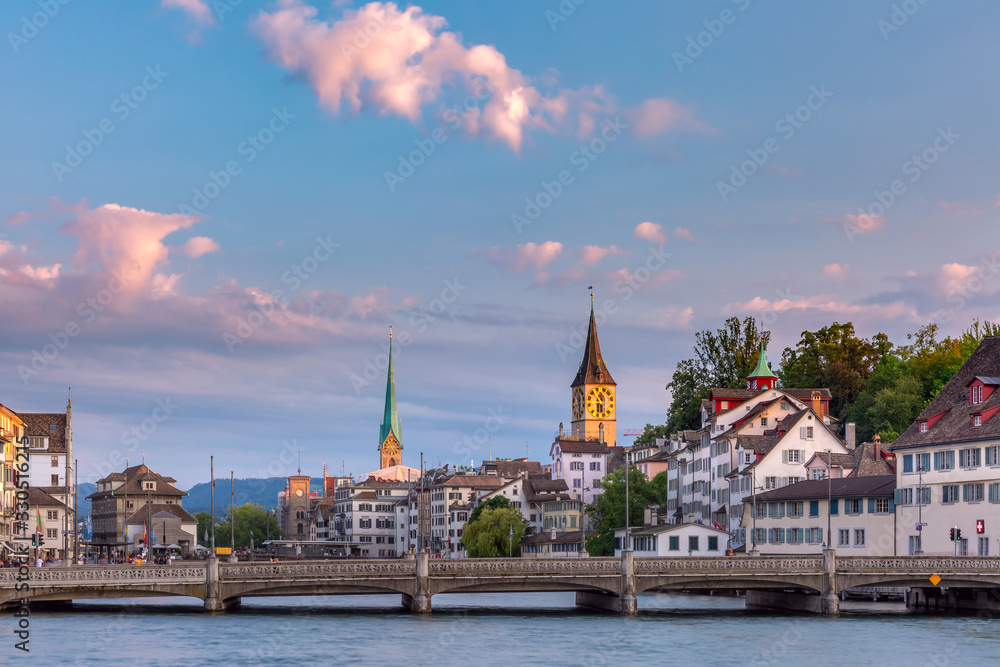 Panoramic view of famous Fraumunster and Church of St Peter and river Limmat at sunrise in Old Town of Zurich, the largest city in Switzerland