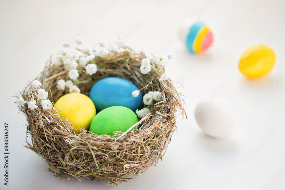 Colorful easter eggs in a bird 's nest on a blue background. Colorful easter eggs in a bird 's nest on a blue background.