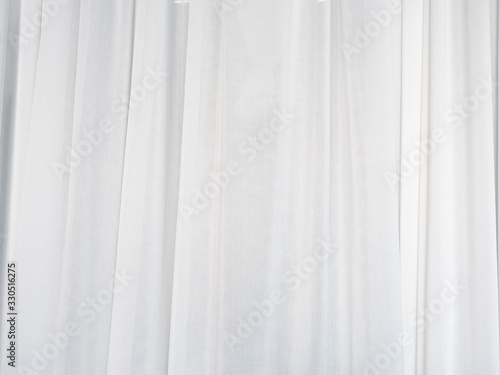 The white curtain is made of muslin fabric with soft sunlight in the morning passing through.