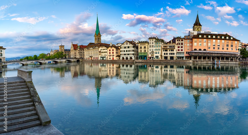 Panoramic view of famous Fraumunster, St Peter church and river Limmat at sunrise in Old Town of Zurich, the largest city in Switzerland
