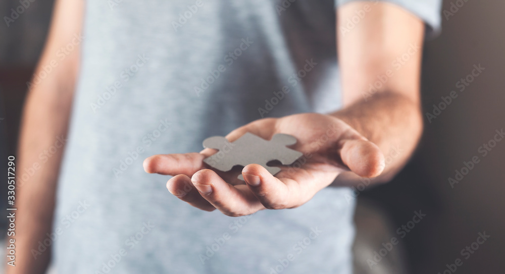 businessman holds a piece of the puzzle in his hand businessman holds a piece of the puzzle in his hand