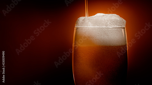 Fotografie Lager beer settles in the glass with a white cap of foam