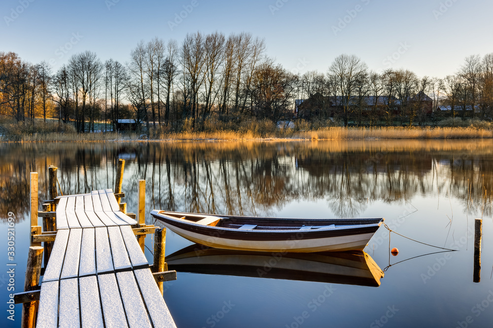 Boat and frosty jetty on lake, Sweden