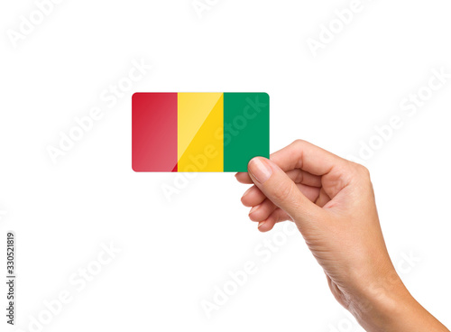 Beautiful hand holding Guinea flag card on white background