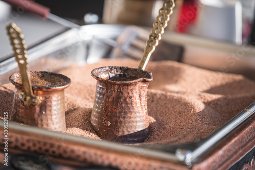 Preparation of Turkish coffee in the cezve in the sand