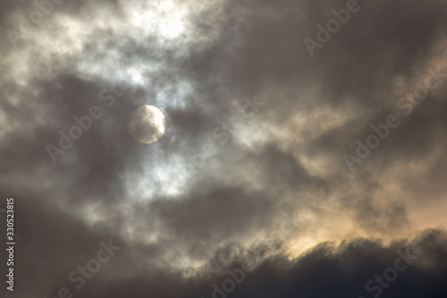 The afternoon sun covered by dense clouds over the highlands of the central Andean mountains of Colombia.