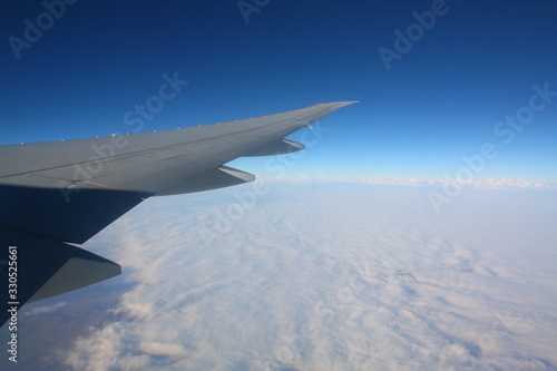 Jet airplane wing illuminator view. Blue sky