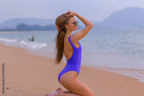 Beautiful slim girl in a blue swimsuit on the ocean. © fotoplaton