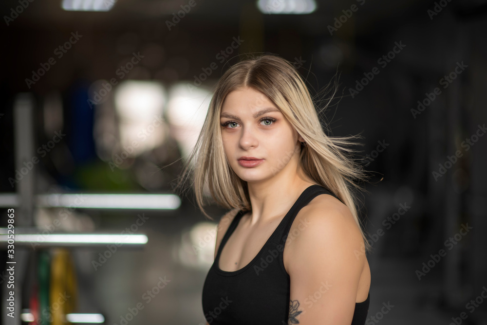 Portrait of a blonde girl with developing hair in a fitness gym. Portrait of a blonde girl with developing hair in a fitness gym.