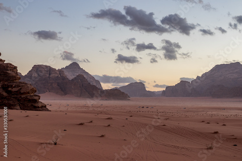 Kingdom of Jordan  Wadi Rum desert  sunset winter day scenery landscape with white puffy clouds and warm colors. Lovely travel photography. Beautiful desert could be explored on safari. Colorful image