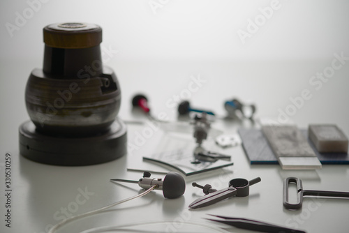 Various Engraver Tools On White Desk. Professional engraver equipment for jewelleries manufacturing Craftsman Engraver Jewellers Workplace Concept