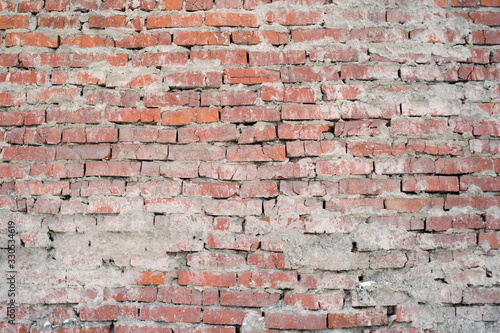 The texture of the brickwork from the old red brick. Exterior of the wall  traces of cement.