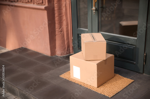 Delivered parcels on door mat near entrance. Space for text