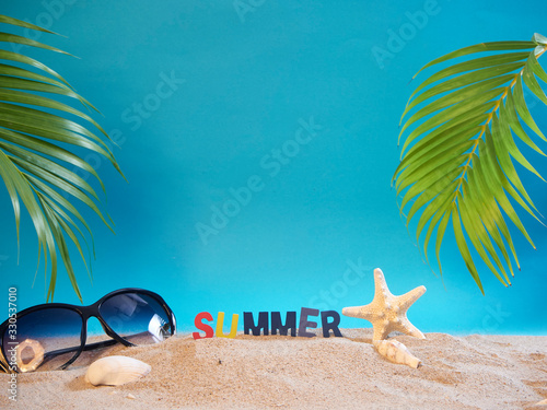 Fototapeta Naklejka Na Ścianę i Meble -  Sunglasses on beach with blue background.