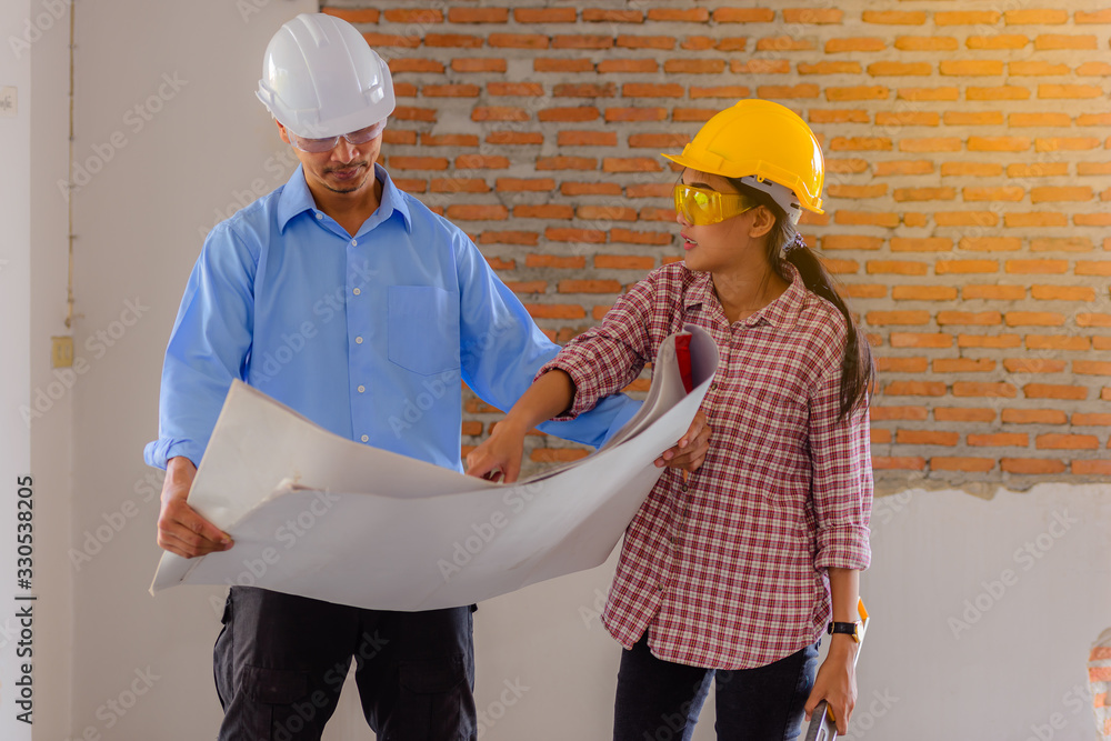 Engineer man and woman checked blueprint in construction site Engineer man and woman checked blueprint in construction site