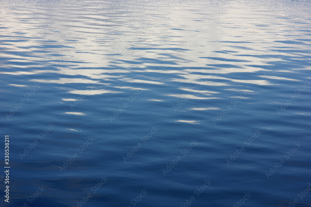 a soothing background with blue water of the river with small ripples and the reflected clouds a soothing background with blue water of the river with small ripples and the reflected clouds
