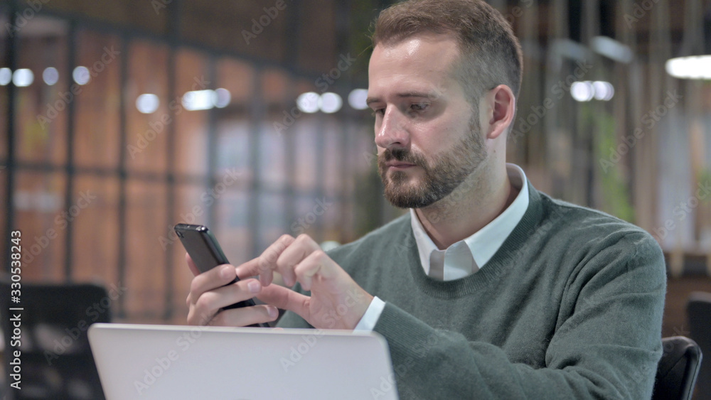 Close Up Shoot of Young Man using Smartphone and Computer Close Up Shoot of Young Man using Smartphone and Computer