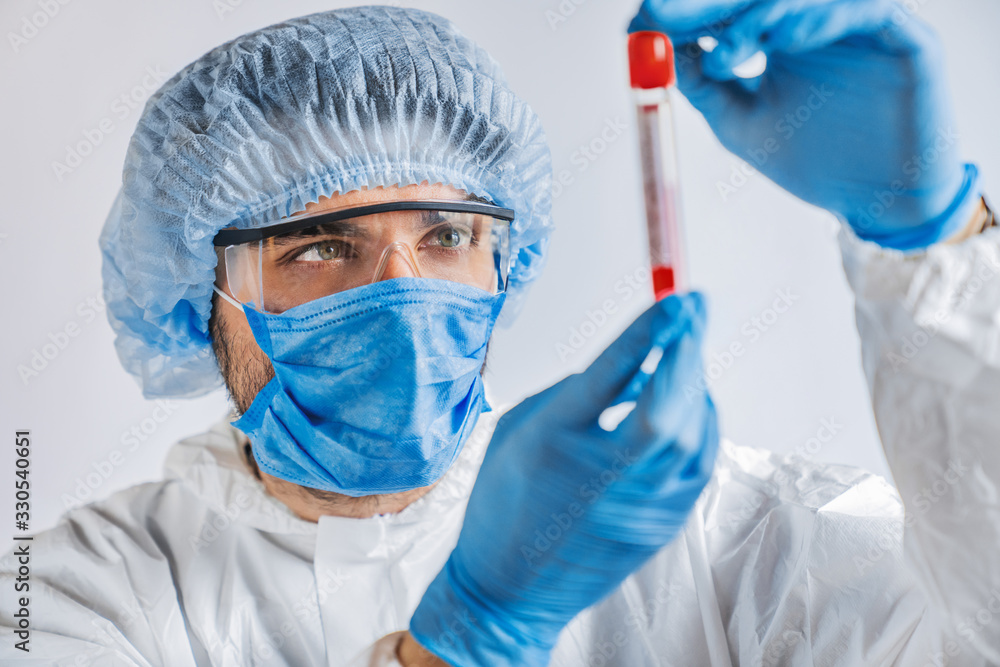 Male scientist holding test tube with blood for virus analyzing Male scientist holding test tube with blood for virus analyzing