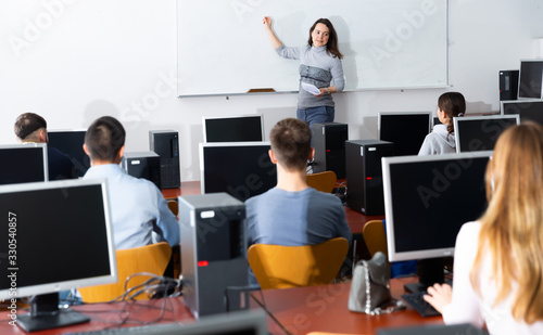 Female coach lecturing adult students in class