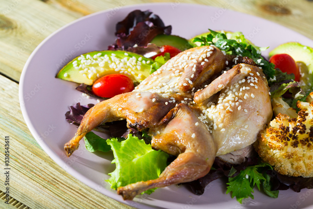 Delicious quail-tobacco with salad from avocado and fresh herbs