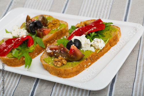 Sandwiches with guacamole, tomatoes, pepper and feta cheese