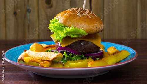 Heeseburger with beef, tomato, cheese, cucumber and french fries photo