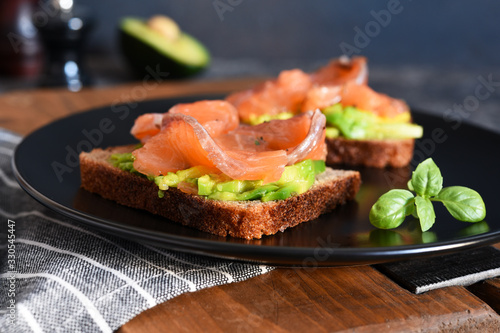 Sandwich with avocado and salmon for breakfast on the kitchen table.