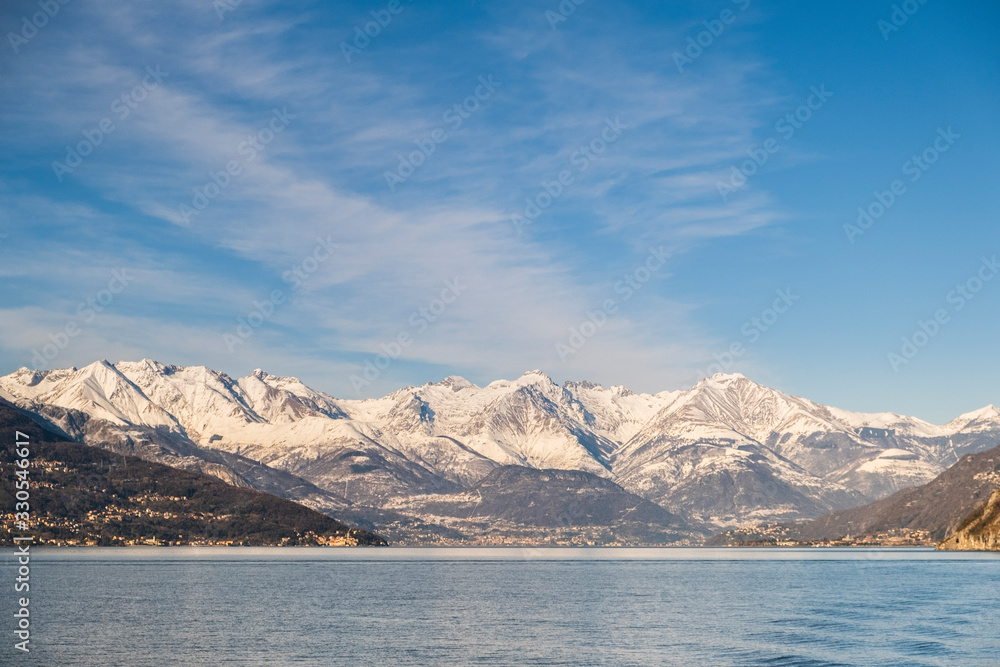 Snowy peaks of Alps mountains on a clear sunny day, panorama of Lago di Como