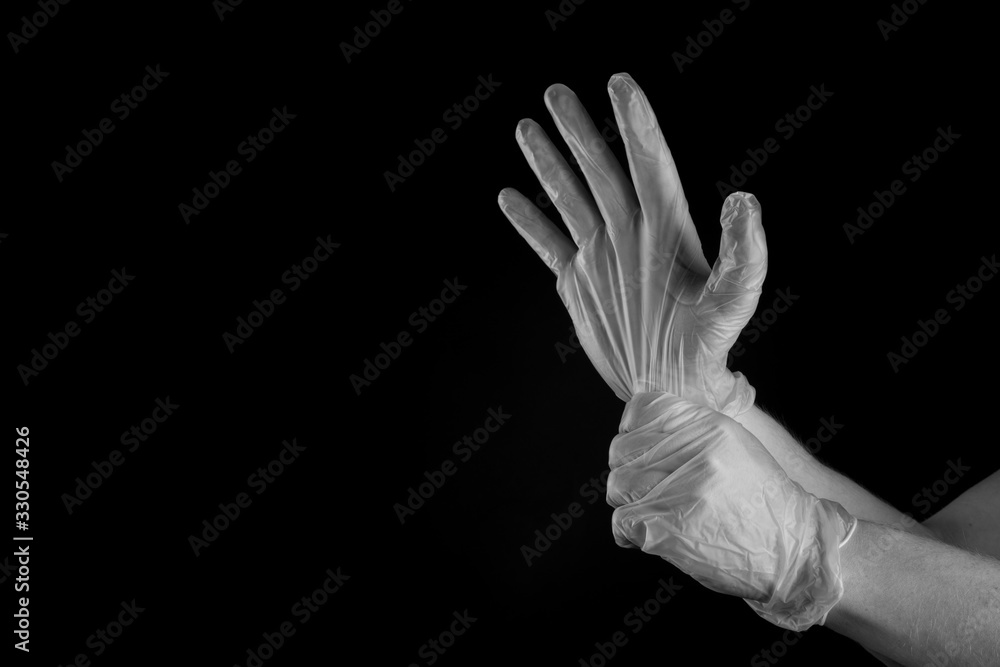 Man putting medical rubber gloves on , isolated on black background copy space Man putting medical rubber gloves on , isolated on black background copy space