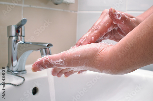 Mujer lavándose las manos y desinfectando de virus y suciedad. photo