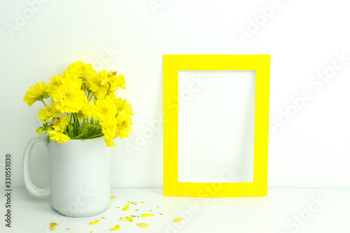 Frame mockup. Blank frame with yellow flowers in vase. photo