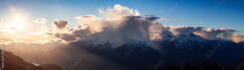 Beautiful Dramatic Canadian Mountain Landscape View during a sunny and cloudy winter sunset. Taken in Squamish, British Columbia, Canada. Nature Background Panorama