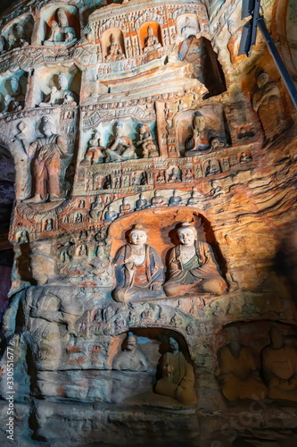 Painted walls with buddha and monk statues in niches. World cultural heritage site and Buddhist Caves Art Treasure Houses in Yungang Grottoes near Datong, Shanxi Province, China 