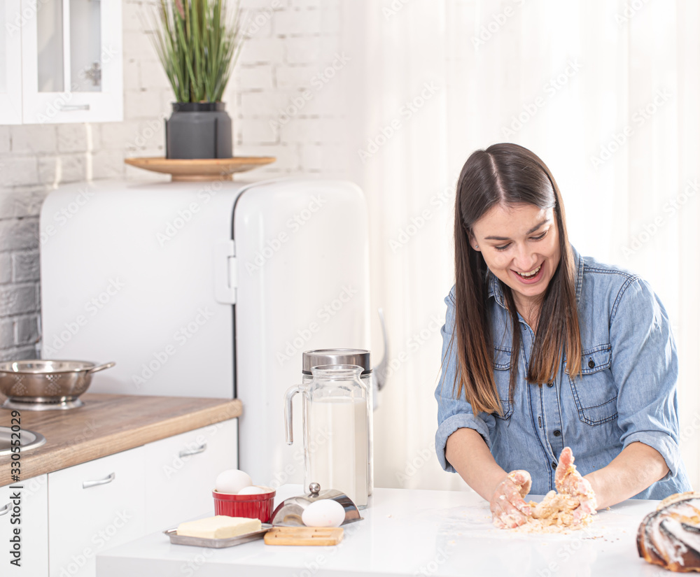 A young beautiful woman prepares homemade cakes in the kitchen. A young beautiful woman prepares homemade cakes in the kitchen.