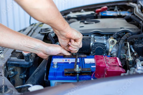 repair and installation of the battery under the hood of a car