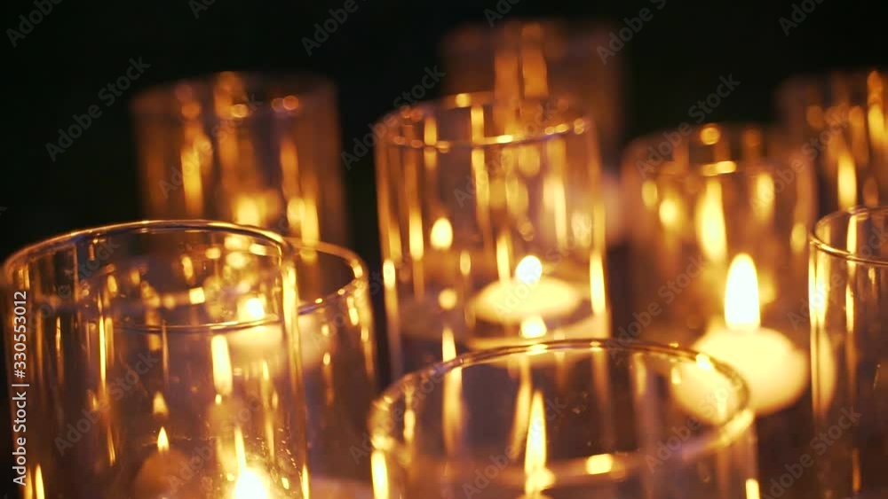 Close up. candle in a glass flask romantic atmosphere at night or evening wedding ceremony. Burning candles. Large candles burn in glass flasks. hall. Romantic evening. Close up. candle in a glass flask romantic atmosphere at night or evening wedding ceremony. Burning candles. Large candles burn in glass flasks. hall. Romantic evening.