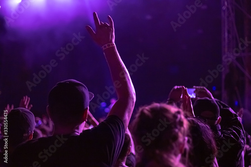 man raised his hand up at a music concert
